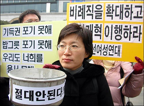 '한나라당, 민주당, 자민련의 후안무치한 정치개악 시도 중단을 촉구하는 공동 기자회견'에 참석한 시민사회단체 활동가가 '지역구 증원 절대 안된다'는 구호를 적은 냄비를 들고있다. 